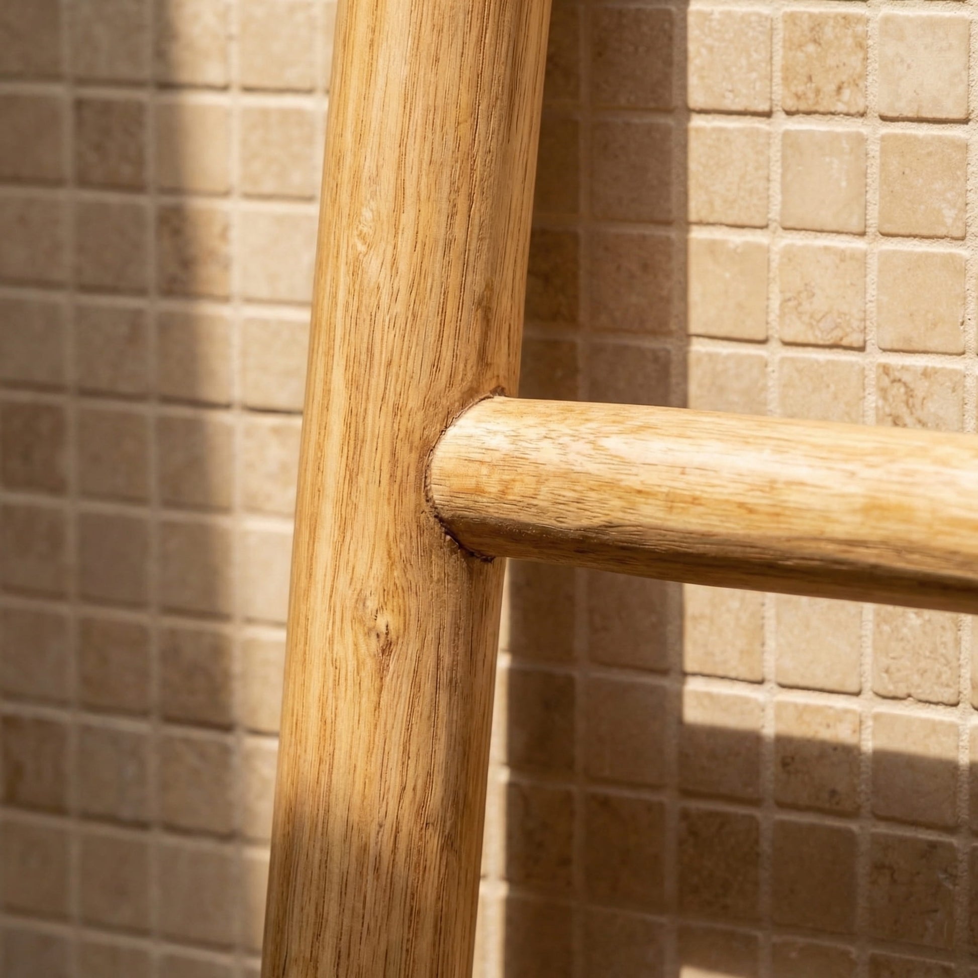 Wooden chair backrest against a tiled wall