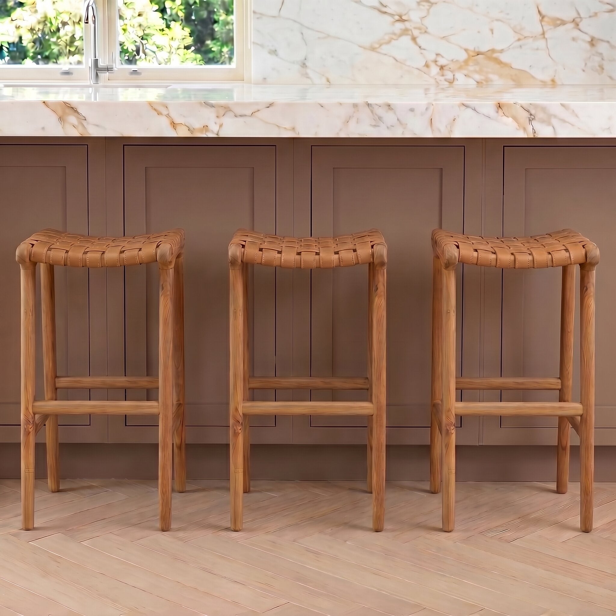 Three leather wooden bar stools in a kitchen setting with marble backsplash and wooden floor.