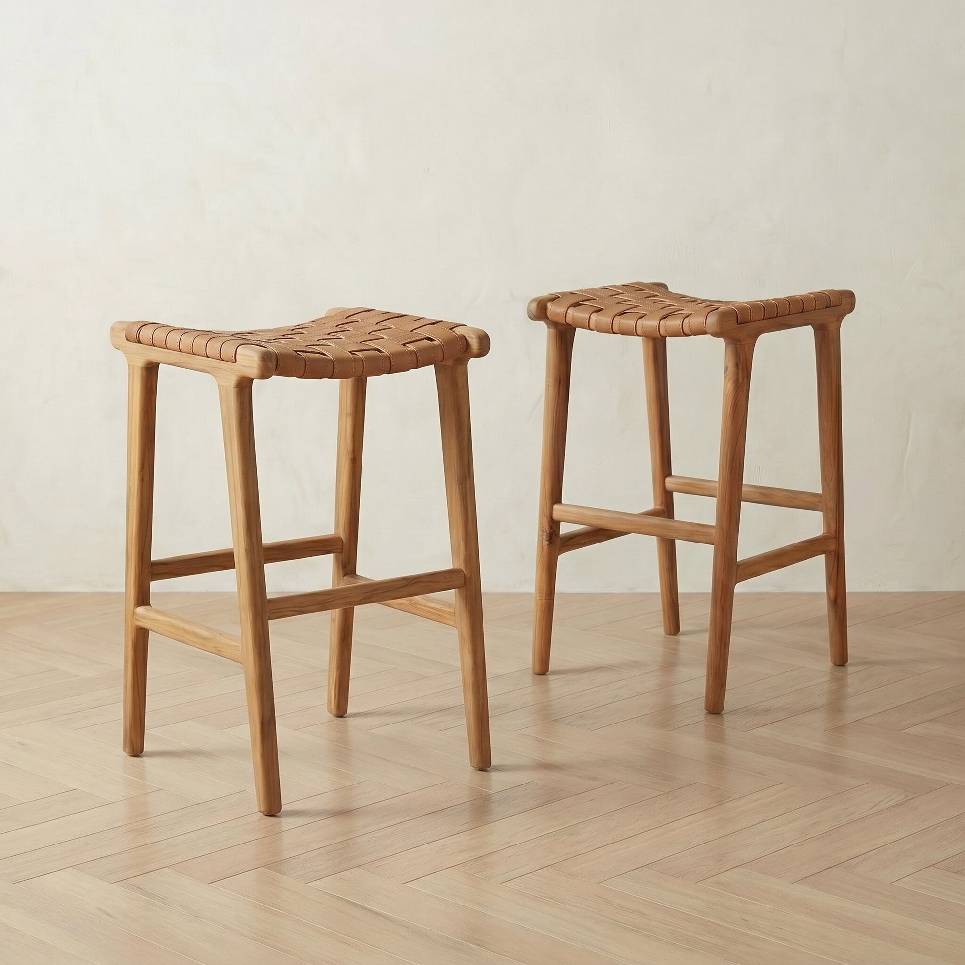 Two wooden bar stools with woven seats on a wooden floor.