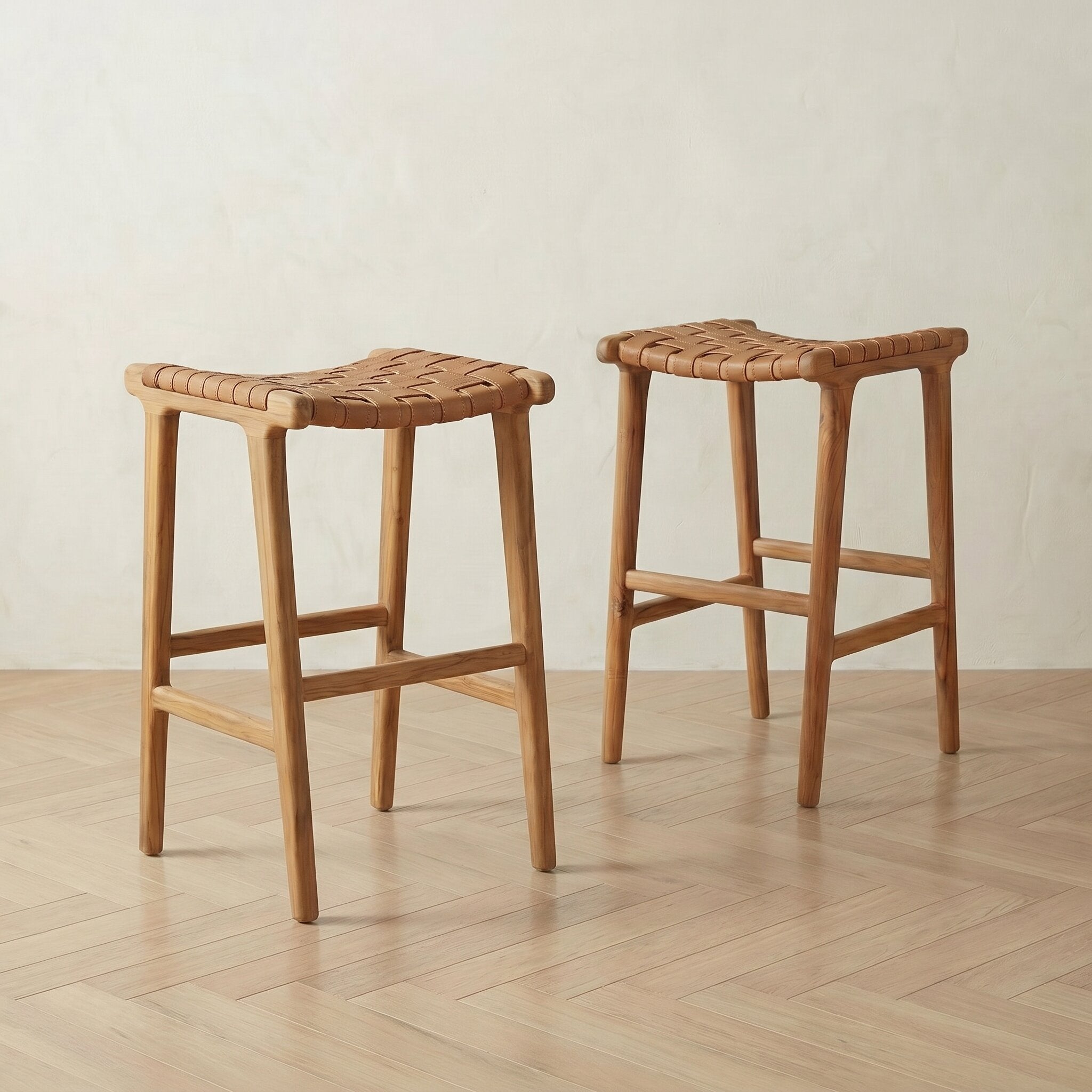 Two wooden bar stools with woven seats on a wooden floor.