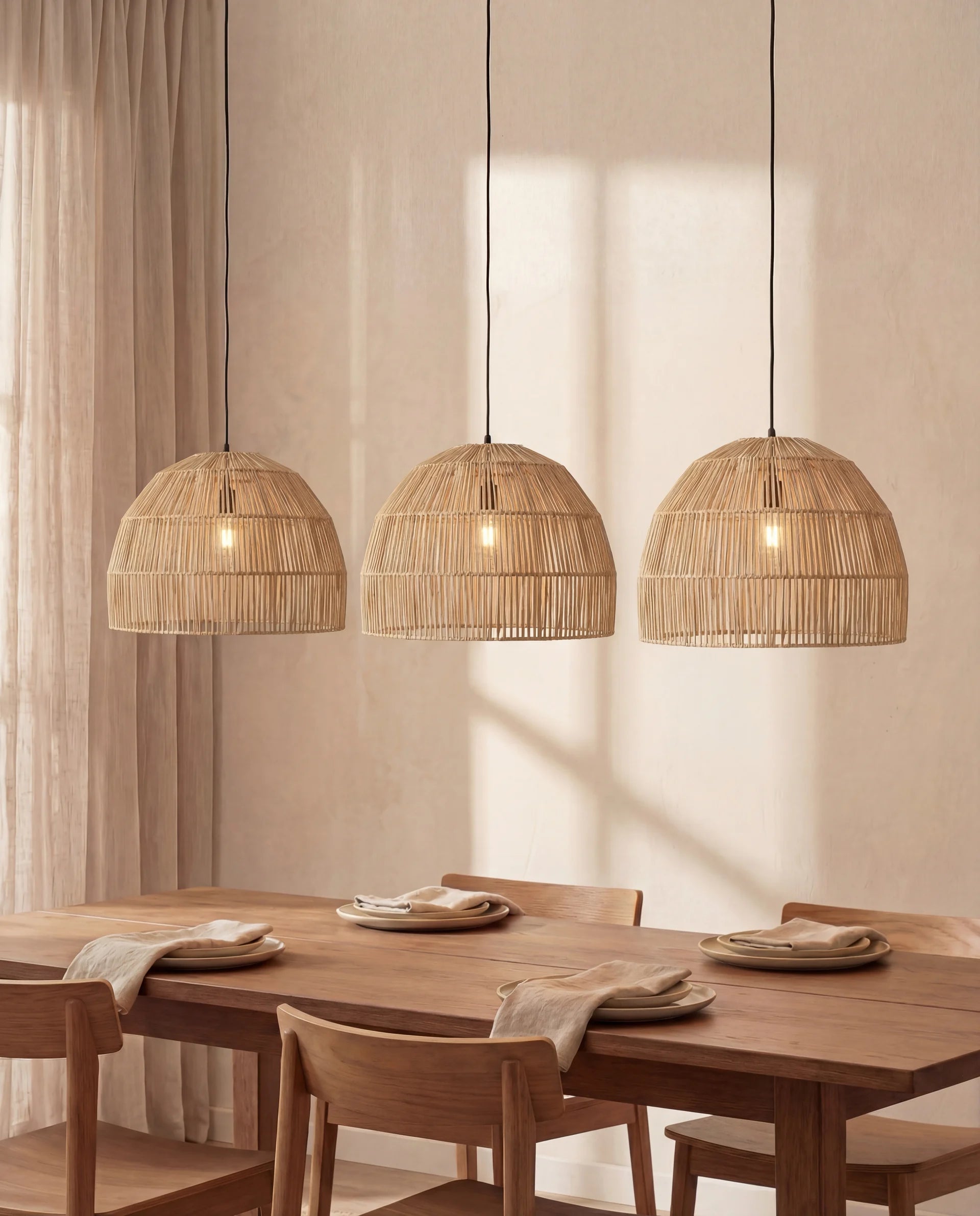 Three woven pendant lights hanging above a wooden dining table with chairs.