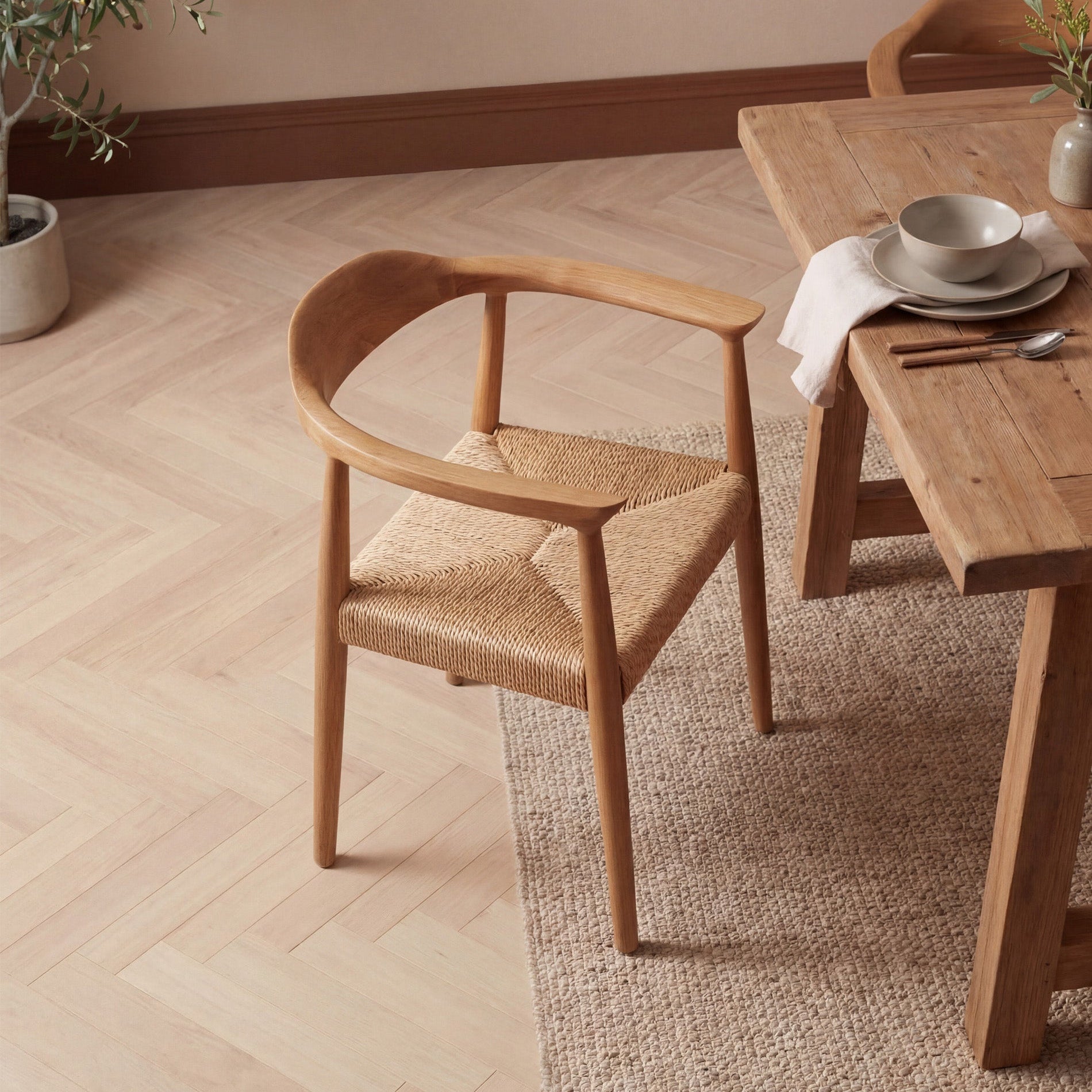 Wooden chair and dining table with a neutral color scheme in a room with plants.