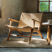 Rattan armchair in a room with a window and small table