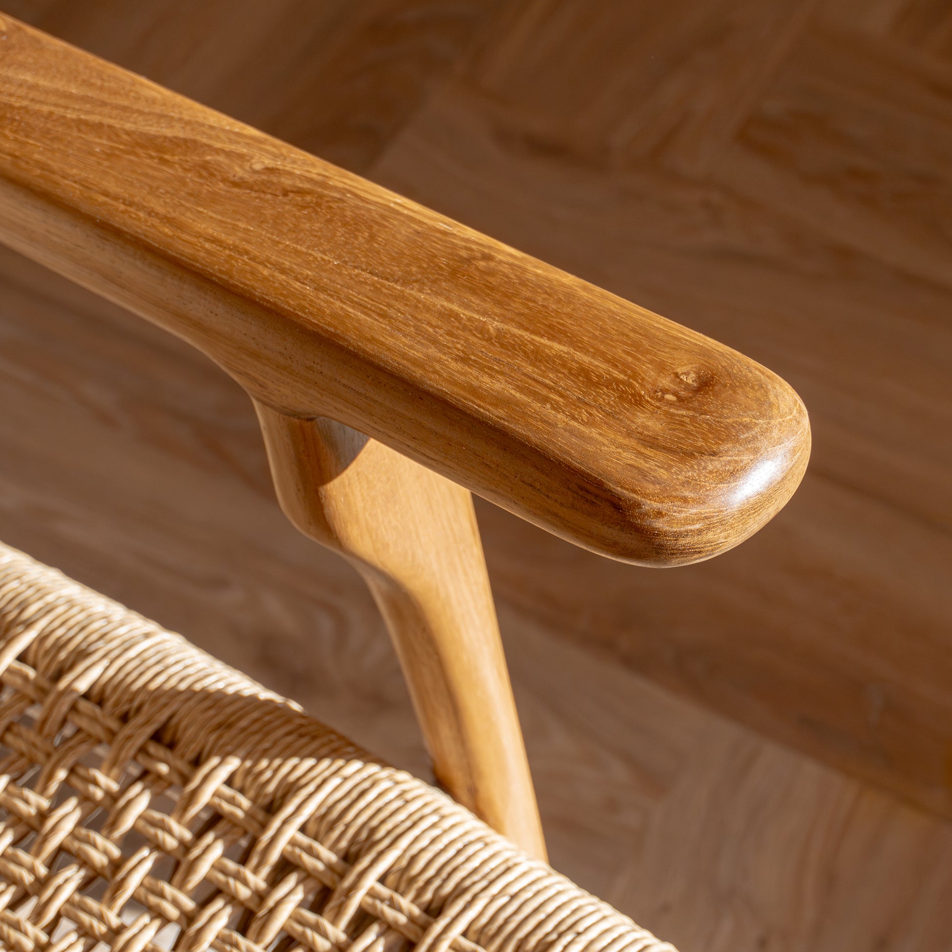 Close-up of a wooden accent chair arm and woven seat