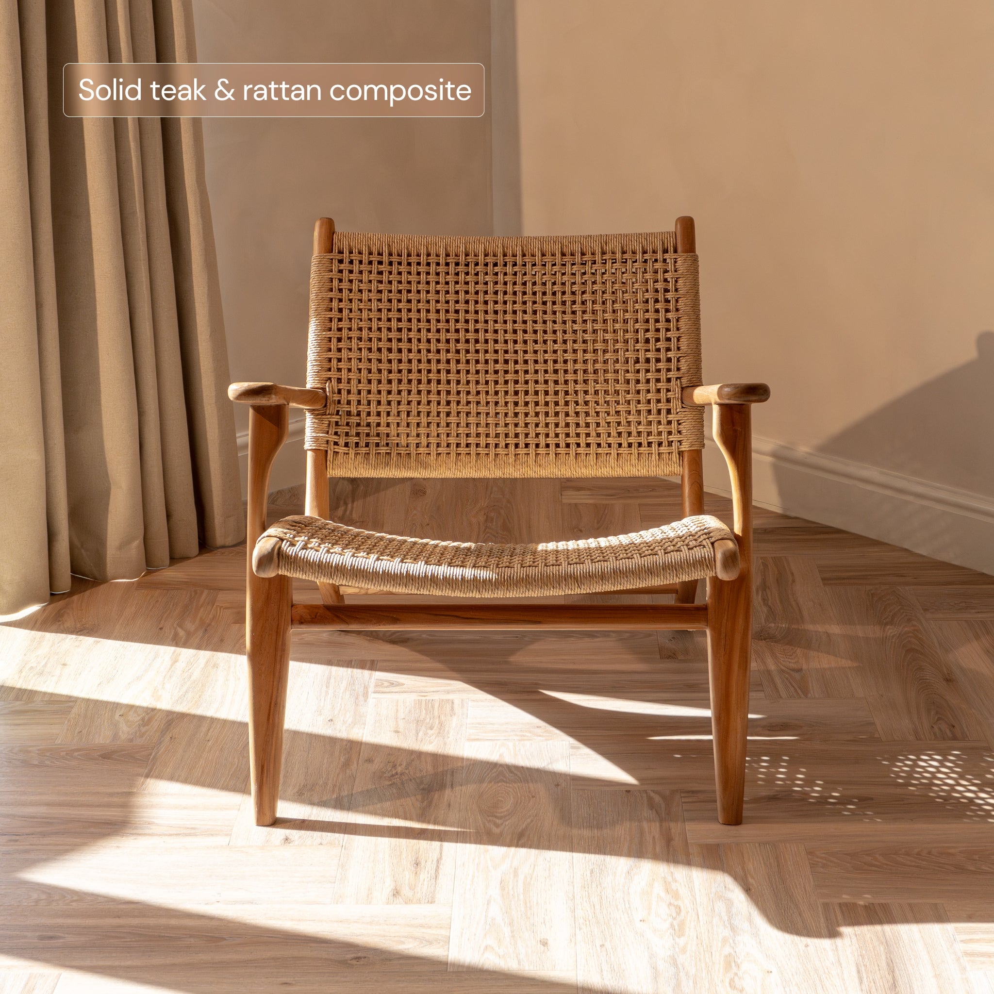 Rattan accent chair with wicker back and seat in a room with sunlight streaming through curtains