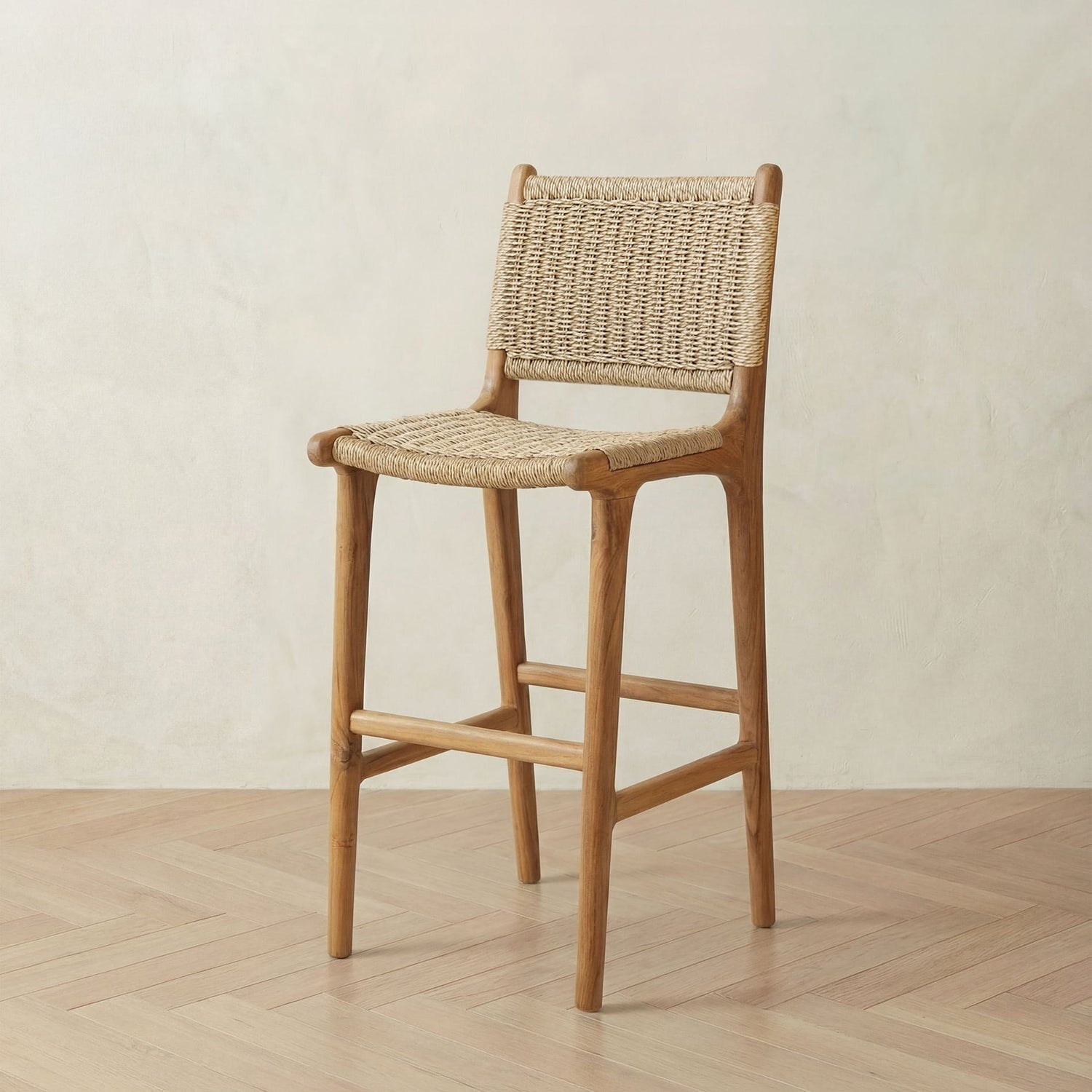 Rattan bar stool with woven backrest and seat on a wooden floor.