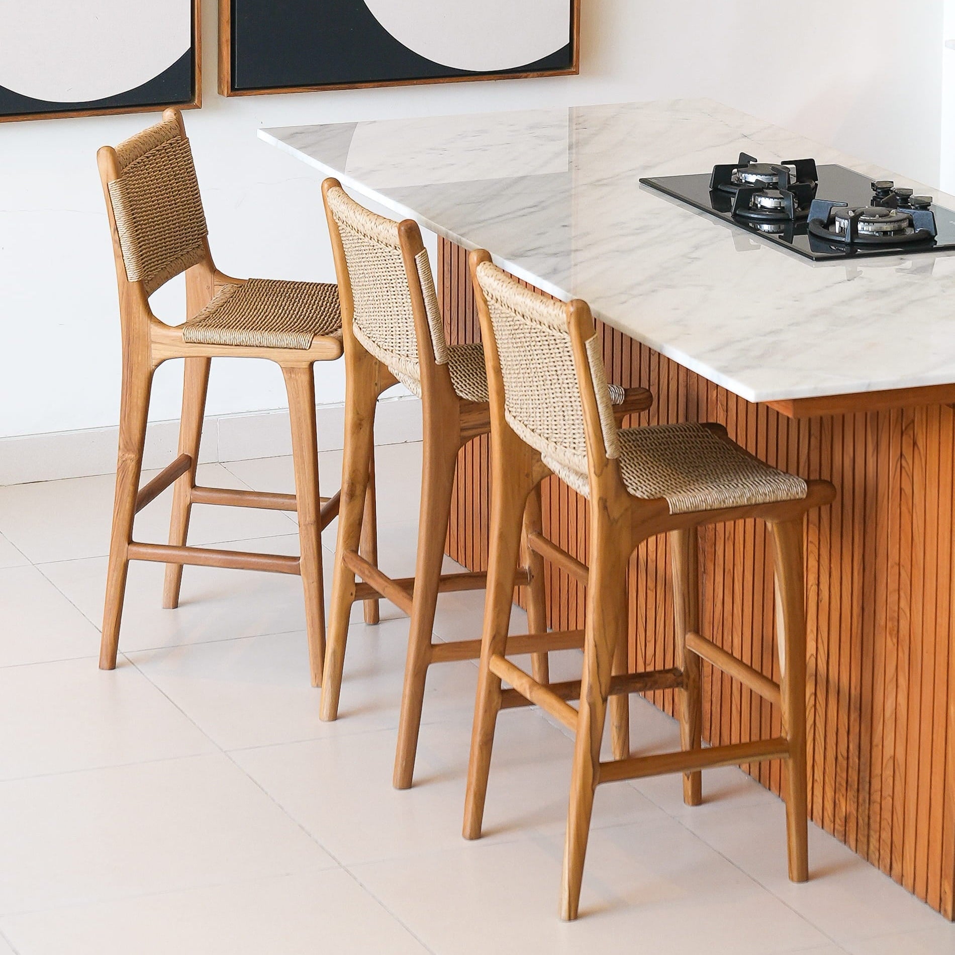 Wooden bar stools in front of a kitchen island with a modern decor background.