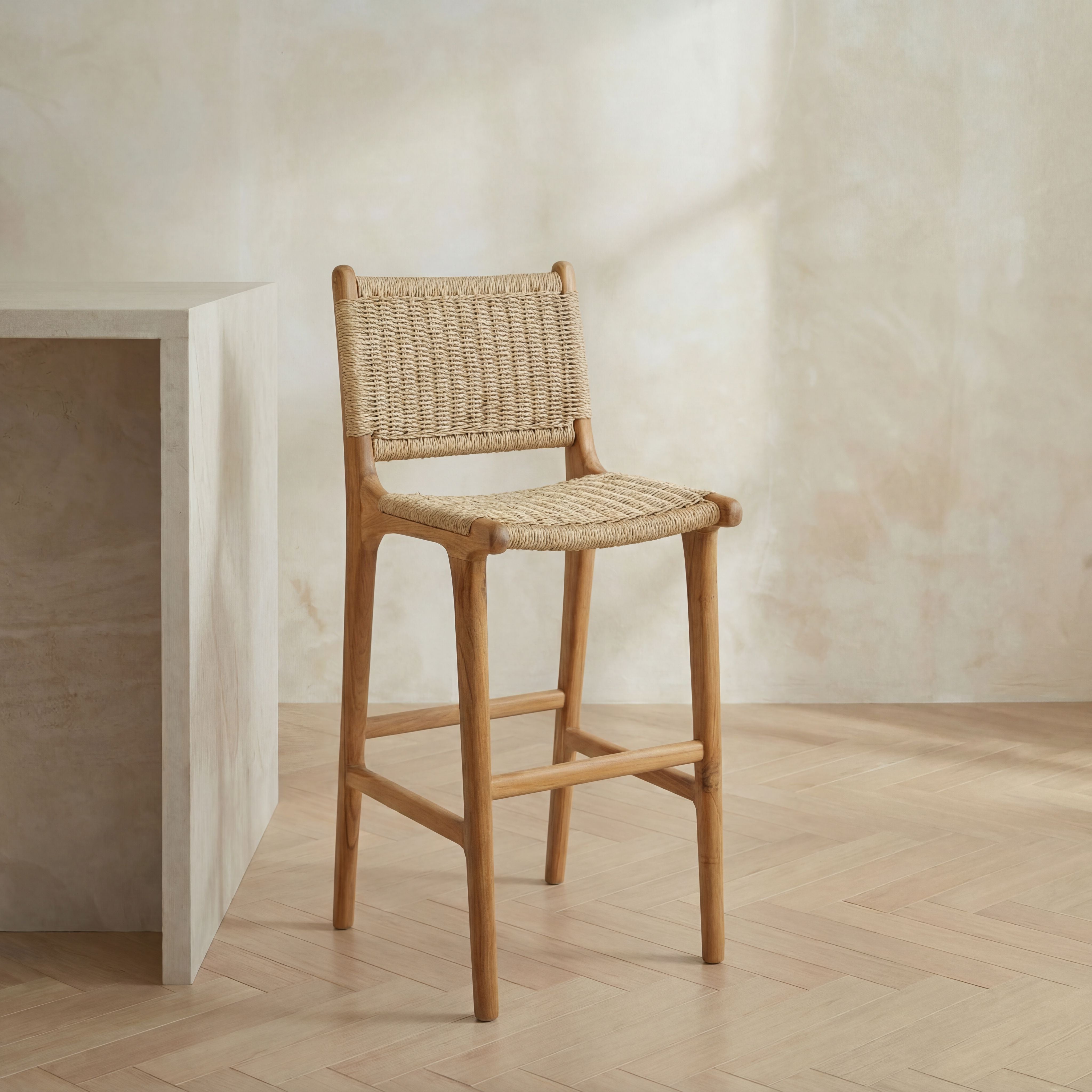 Woven bar stool in a minimalistic room with a neutral color palette.