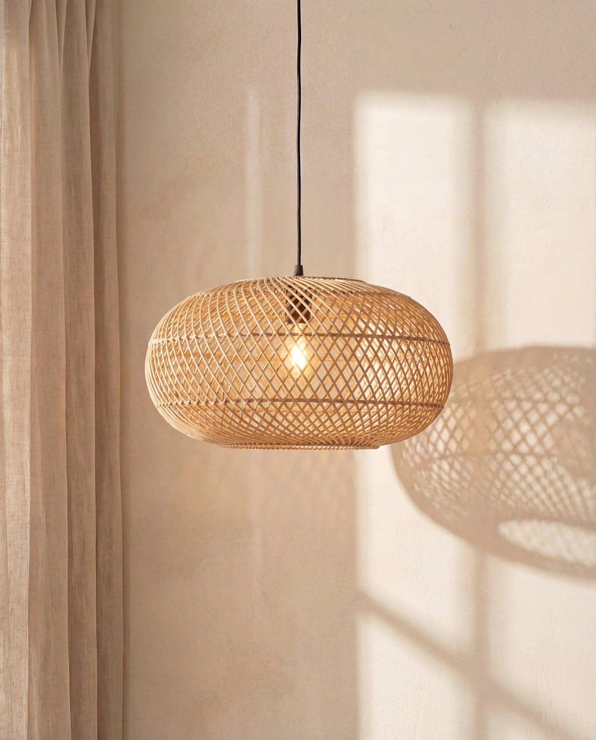 Woven pendant light hanging against a neutral wall with soft shadows.
