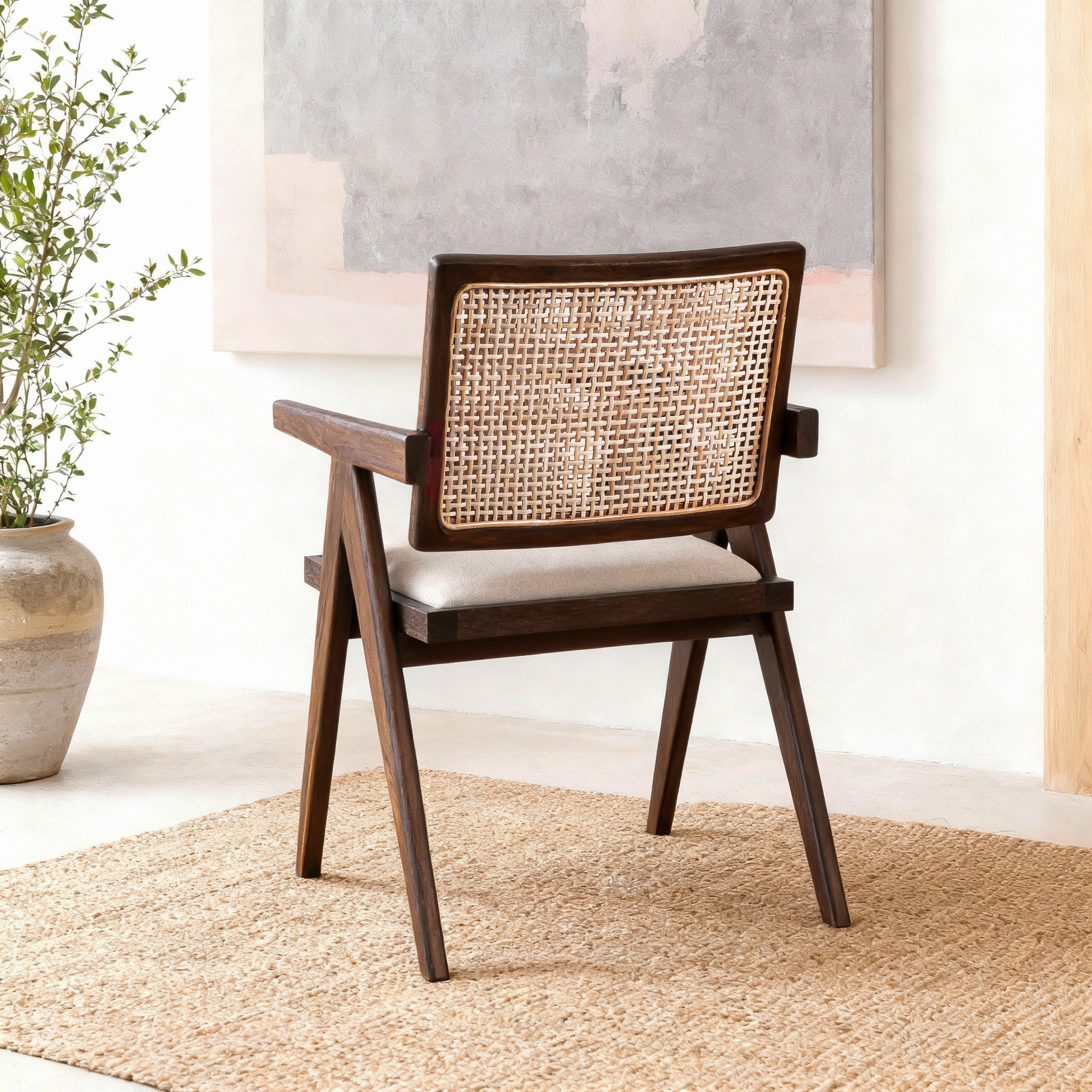 Wooden chair with wicker backrest in a room with a plant and rug