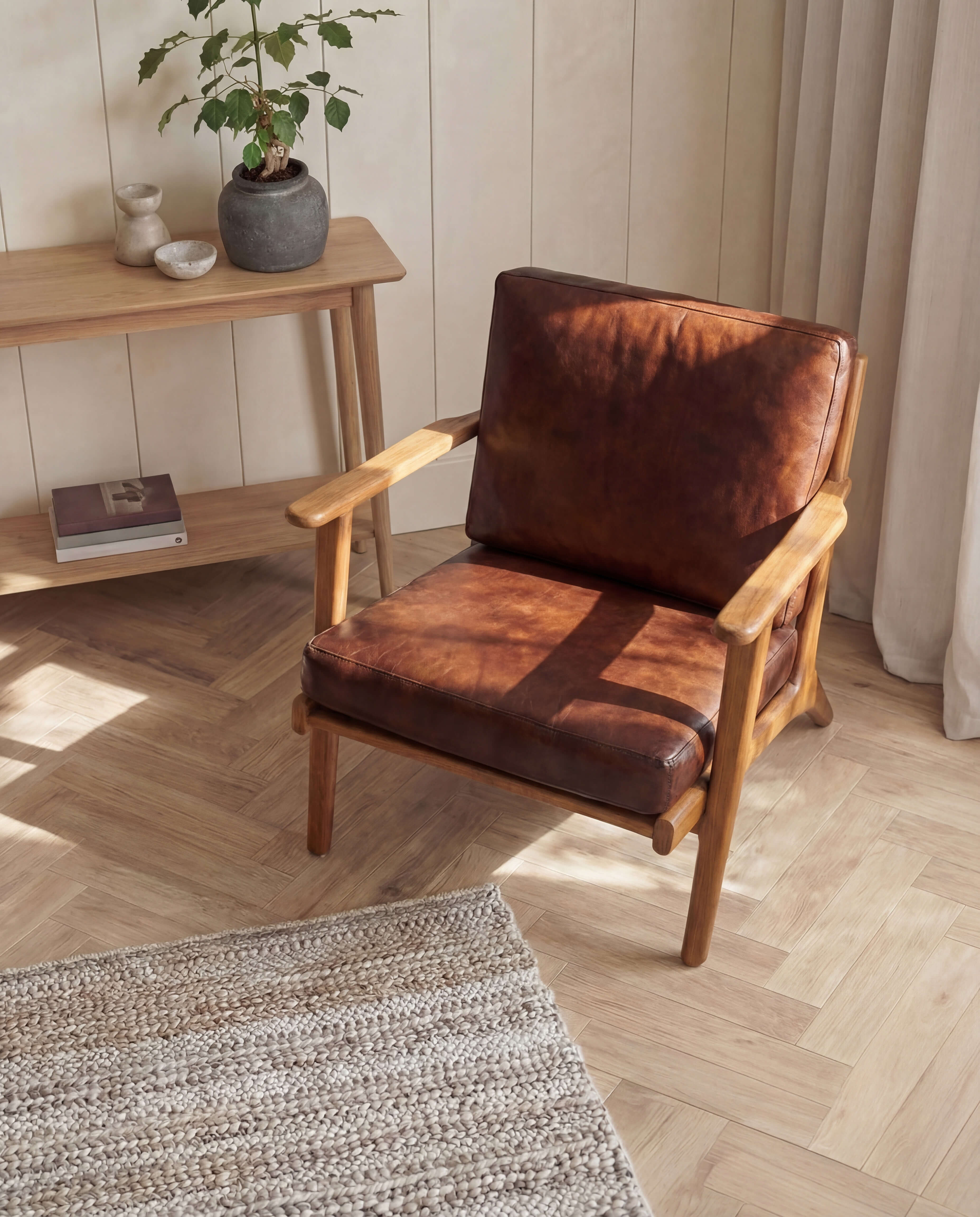 Brown leather armchair in a room with wooden floor and light-colored walls.