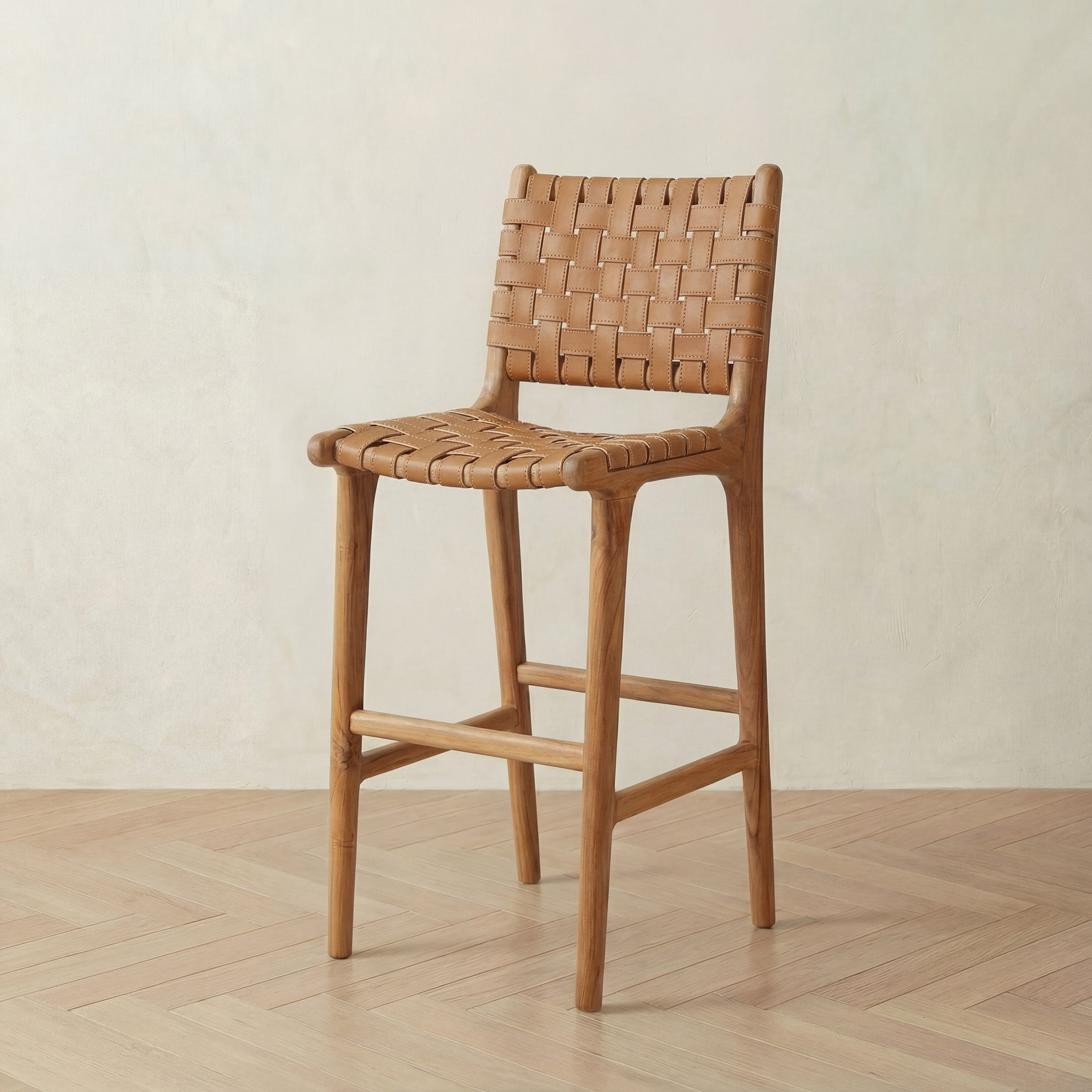 Wooden bar stool with woven backrest on a wooden floor.