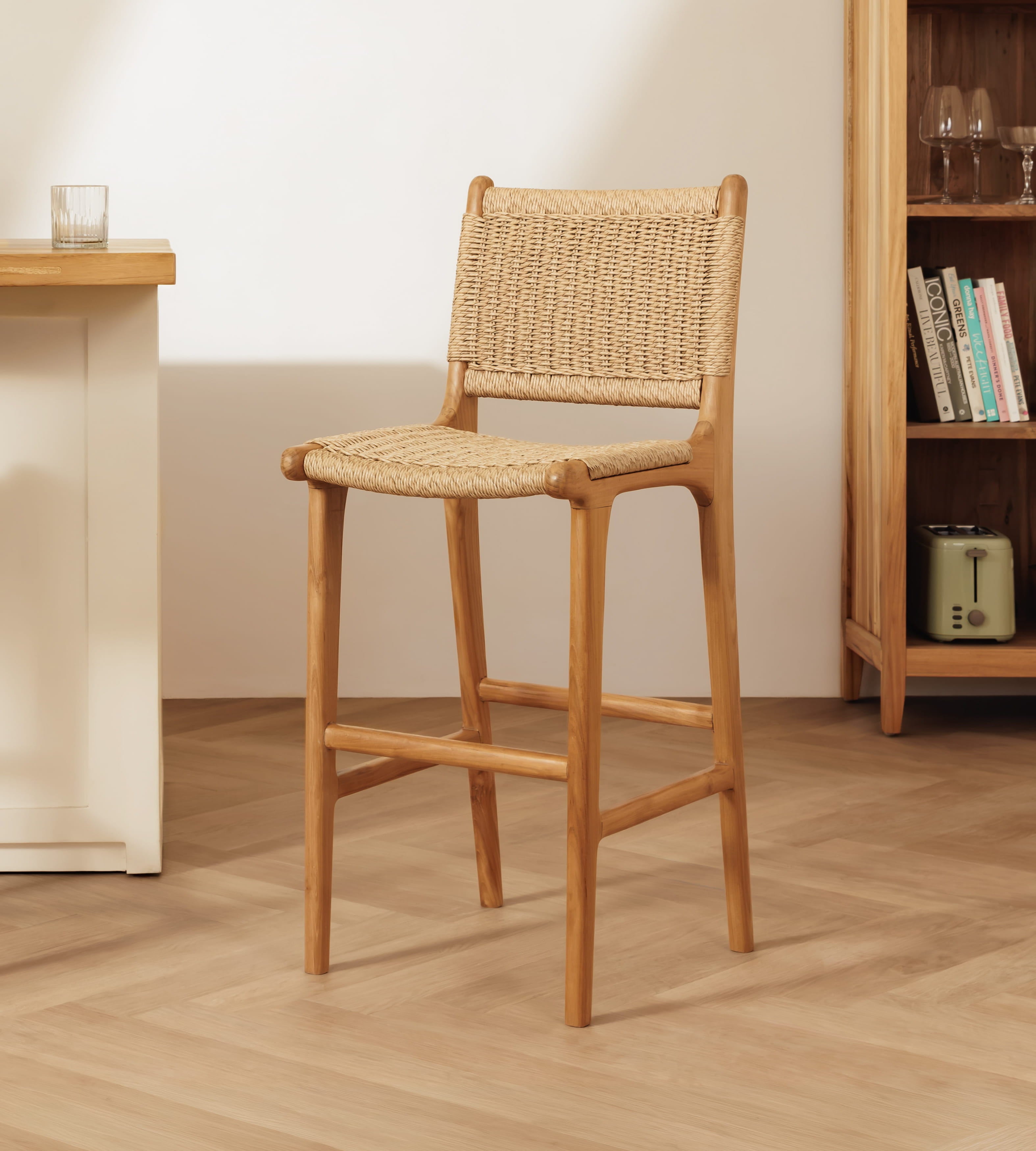 Rattan bar stool placed in a herringbone floor in a kitchen setting